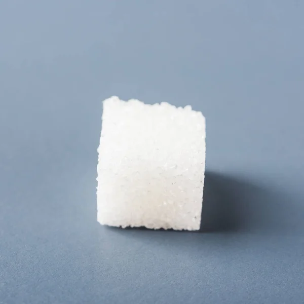 灰色の背景に隔離された1つの白い砂糖キューブ甘い食品成分 糖尿病やカロリー摂取コンセプトの健康高血圧リスク — ストック写真