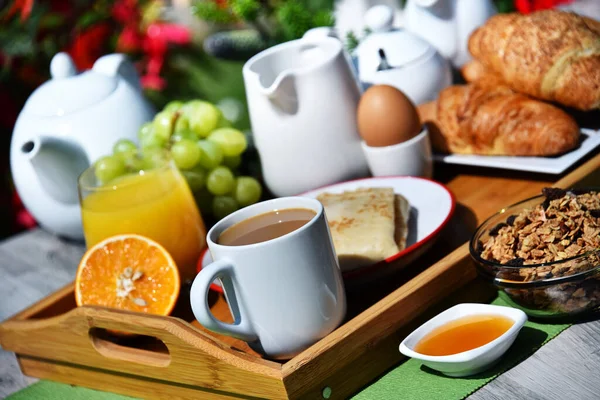 Śniadanie Serwowane Kawą Sokiem Pomarańczowym Rogalikami Płatkami Zbożowymi Owocami Ogrodzie — Zdjęcie stockowe