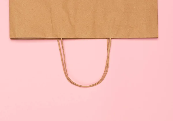 最小限のフラットレイアウト コピースペースとピンクの背景に空のクラフト紙袋 廃棄物フリーコンセプト — ストック写真