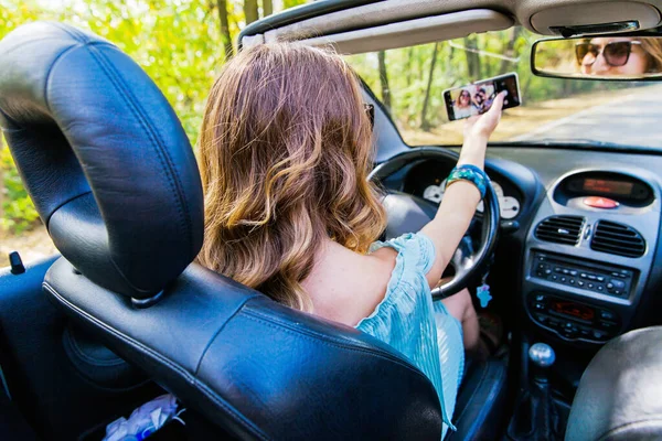 Atrakcyjna Młoda Kobieta Jeżdżąca Kabrioletem Fotografowanie Telefonem Komórkowym Podczas Jazdy — Zdjęcie stockowe