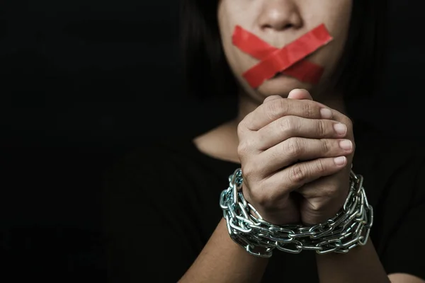 stock image Asian woman blindfold wrapping mouth with red adhesive tape and she was hand tethered on black background. Freedom speech censorship and stop talk, International Human Right day