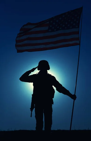 美国陆军士兵的轮廓 海军陆战队员 在夜空的背景下 举着飘扬的国旗 在月光的映照下 向人们致意 英雄主义和爱国主义 军事荣誉观 — 图库照片