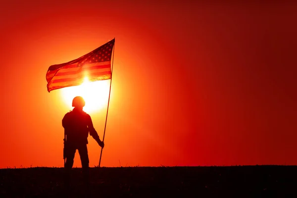 米軍兵士のシルエット 日没を背景に立ちながら旗竿の国旗に手を振っている特殊作戦シューティングゲーム アメリカ軍の英雄 アメリカまたはアメリカ軍の勝利 — ストック写真