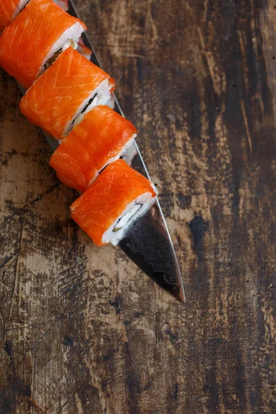 Rolki Sushi Warzywami Serem Łososiem Układane Ostrzu Noża Rustykalnej Tablicy — Zdjęcie stockowe