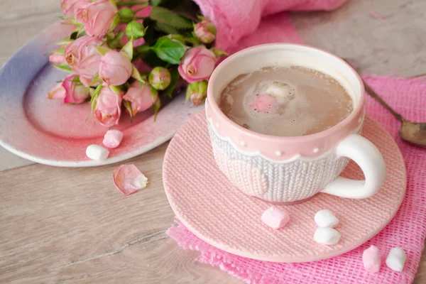 Cocoa chocolate cup with hot drink and white and pink marshmallow, cacao in mug with pink roses, holiday coffee house shop, romantic decoration, mug with knitted effect