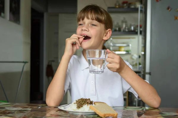 幸せな少女を食べる前に錠剤を飲む — ストック写真