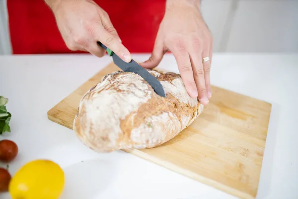 Mannelijke Handen Snijden Brood Houten Snijplank Boven Witte Tafel Hij — Stockfoto