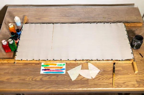 在家里的桌子上固定在木制框架上的空帆布 为蜡染画做准备 — 图库照片