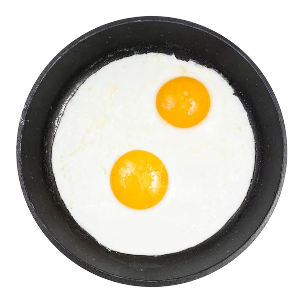 Πάνω Όψη Δύο Τηγανιτών Αυγών Μαύρο Στρογγυλό Τηγάνι Που Απομονώνονται — Φωτογραφία Αρχείου