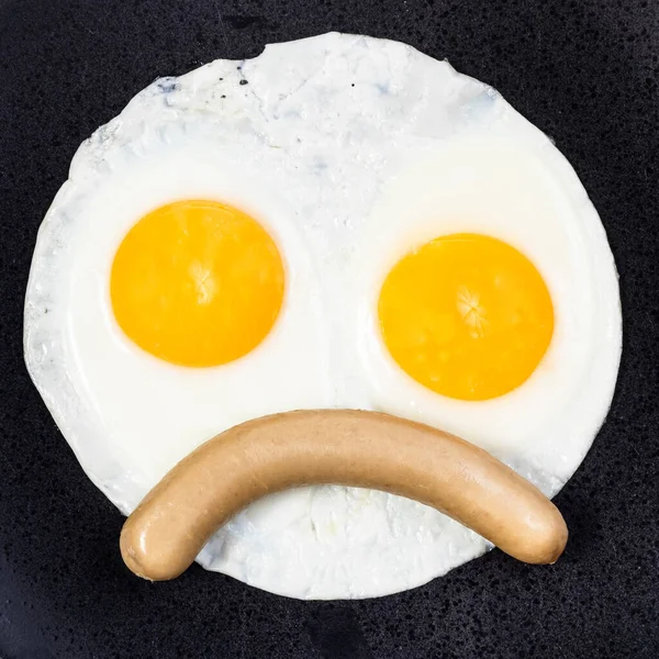Yağda Yumurtanın Üst Görüntüsü Siyah Tabakta Kaynamış Sosis Kaşlarını Çatmış — Stok fotoğraf