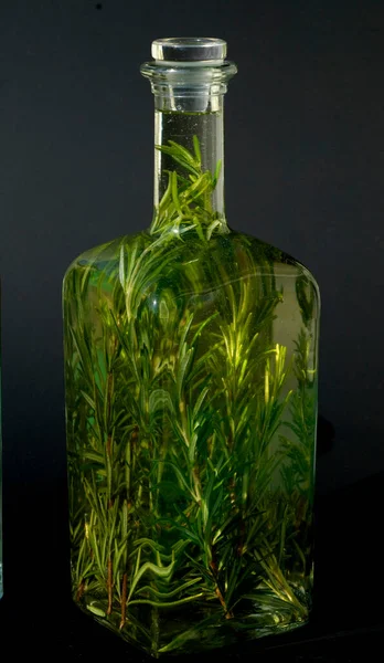 Botella Vidrio Con Hojas Verdes Sobre Fondo Negro — Foto de Stock