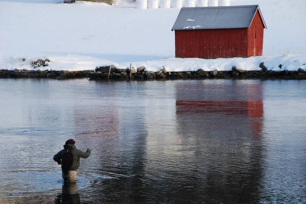 Kırmızı Ceketli Bir Adam Gölde Balık Tutuyor — Stok fotoğraf