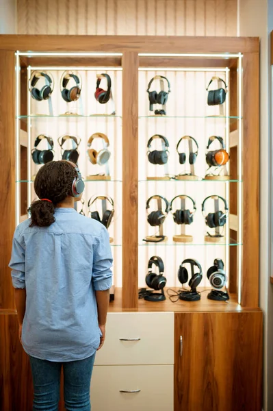 Kvinnan Väljer Hörlurar Akustikbutiken Bakifrån Kvinnlig Person Audio Shop Showcase — Stockfoto