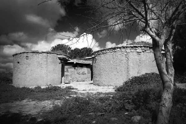 Reconstruction of houses of the Chalcolithic Period (Bronze Age) 3500BC  travel destinations at Lempa Experimental Village in Cyprus black and white monochrome image