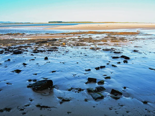 在英格兰诺森伯兰的班布拉斯的潮水退潮时的沙滩和石质海滩 — 图库照片