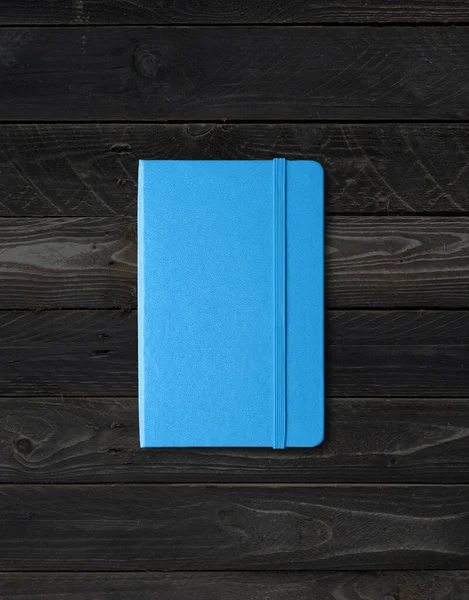 在黑木背景上隔离的蓝色闭式笔记本电脑模型 — 图库照片