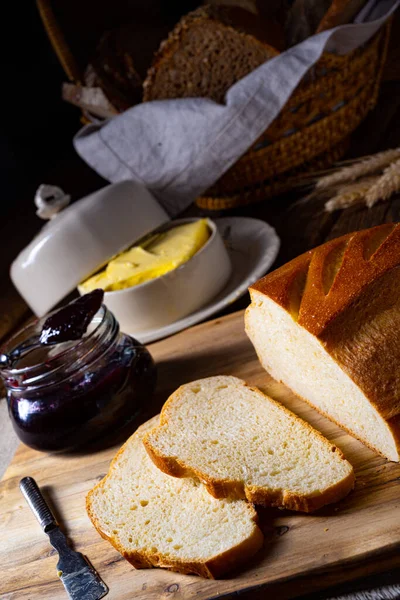 木の板の上にバターと蜂蜜でパンをスライス — ストック写真