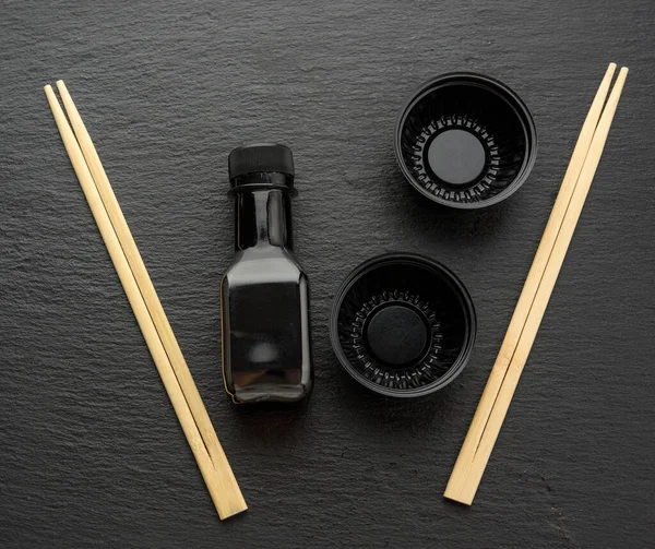 Holzstäbchen Für Sushi Flasche Sojasauce Und Einweg Plastikteller Auf Schwarzem — Stockfoto