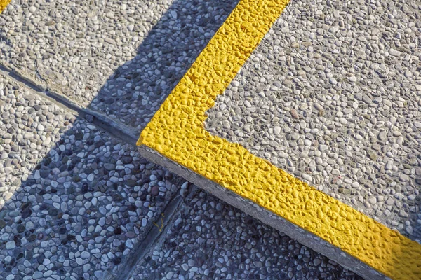 노면에 노란색 콘크리트로 모퉁이의 돌멩이가 — 스톡 사진