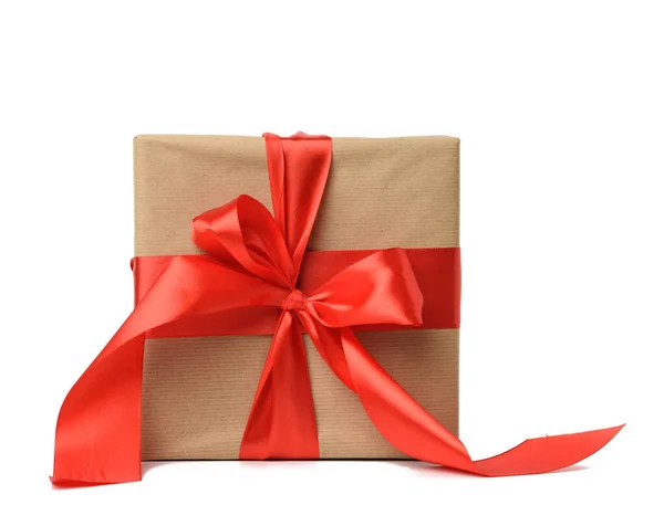 方块盒 用褐色牛皮纸包裹 用红色丝带捆扎 白色背景 — 图库照片