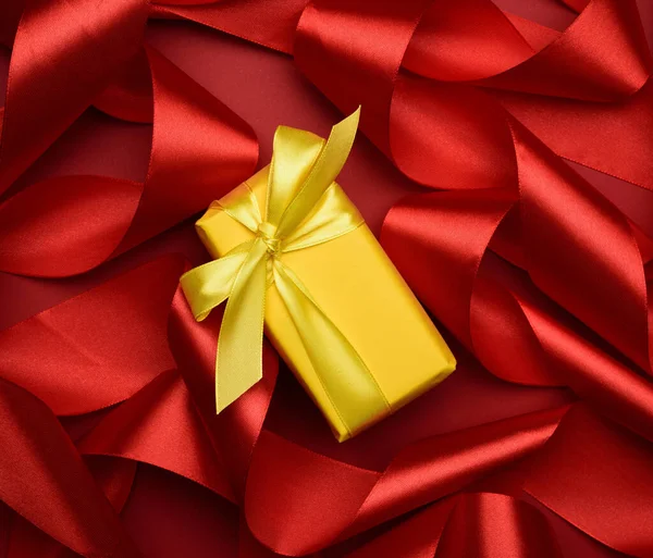 Κουτί Δώρου Είναι Συσκευασμένο Κίτρινο Χαρτί Και Κατσαρά Κόκκινη Κορδέλα — Φωτογραφία Αρχείου