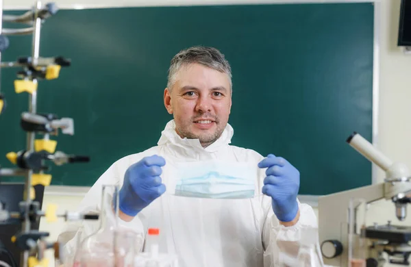 Ένας Νεαρός Επιστήμονας Ένα Χημικό Εργαστήριο Βάζει Μια Προστατευτική Μάσκα — Φωτογραφία Αρχείου