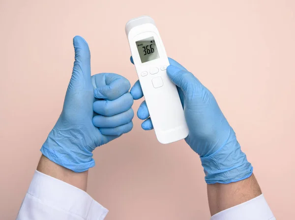 라텍스 장갑을 손으로 온도를 측정하기 온도계를 비접촉 — 스톡 사진