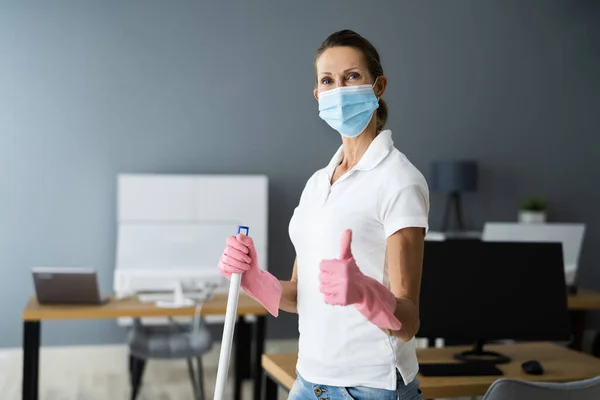 Ofisteki Kadın Temizlikçi Yerleri Maskeyle Temizliyor — Stok fotoğraf