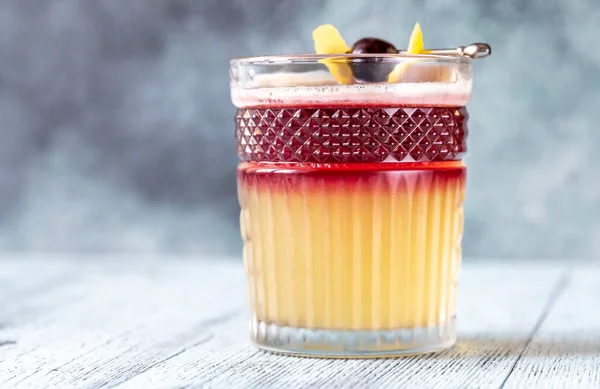 用鸡尾酒樱桃和柠檬皮装饰的纽约葡萄酒杯 — 图库照片