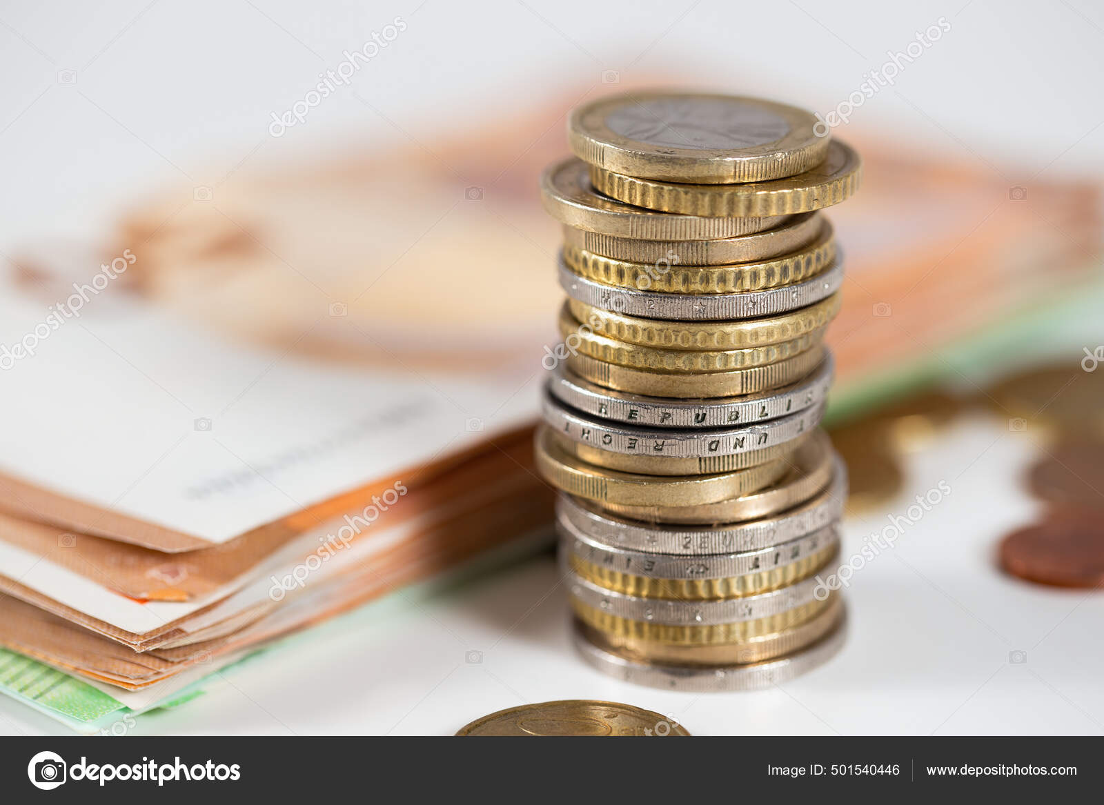 硬币躺在桌子上背景上的钞票模糊不清欧元的钱堆在白桌子上的一栏里财富和财政成功的概念——图库图片©