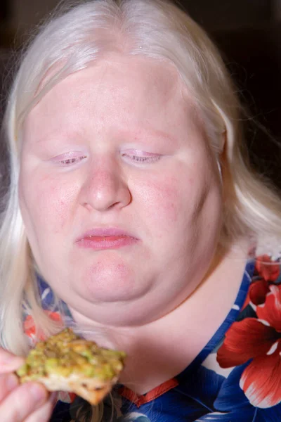 アルビーノ女は真剣に考えているか悲しい考えながら彼女はアボカドトーストを食べる — ストック写真