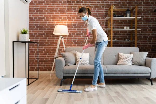 stock image Woman Cleaning The Hardwood Floor With Mop In Face Mask