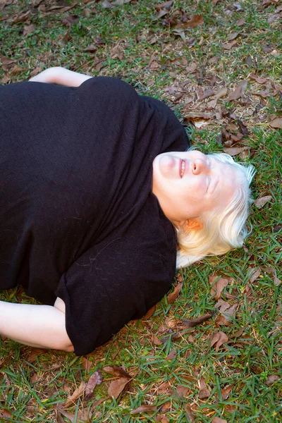 屋外の地面に無意識のうちに横たわる肥満の女性 — ストック写真