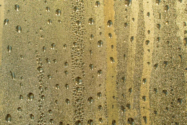 물방울이 추상적 Raindrops 유리잔에 표면에 황금빛으로 빛나고 — 스톡 사진