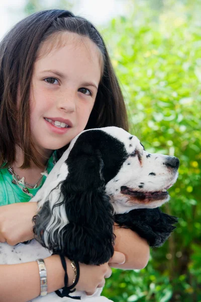 緑の草を背景に犬を飼っている若い女性は — ストック写真