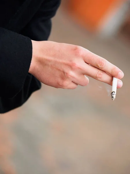 黒い背景でタバコを持ってる男の手 — ストック写真