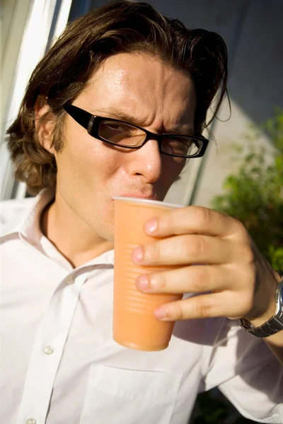 コーヒーとジュースを飲んでる若い男 — ストック写真