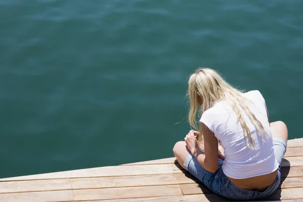 Junge Frau Sitzt Auf Der Seebrücke Und Blickt Auf Das — Stockfoto