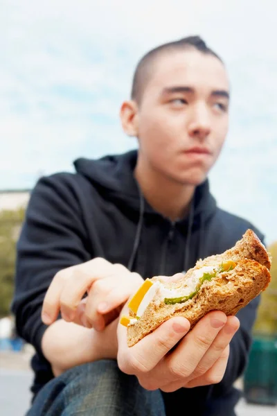 Adam Sahilde Sandviçle Hamburger Yiyor — Stok fotoğraf