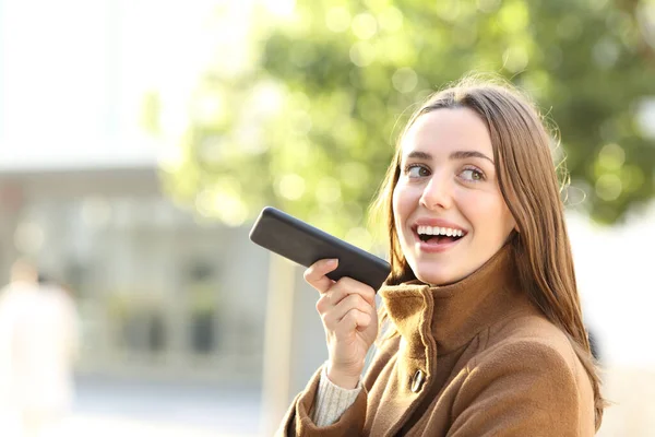 Portret Szczęśliwej Kobiety Dyktującej Wiadomość Smartfonie Zimą Ulicy — Zdjęcie stockowe