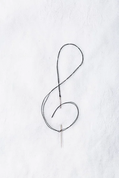 バイオリンのキー形状で白い生地に針を縫製のマクロ 美術の概念 — ストック写真