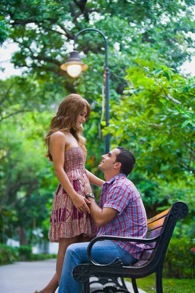 公園のベンチに座っている若いカップルは — ストック写真