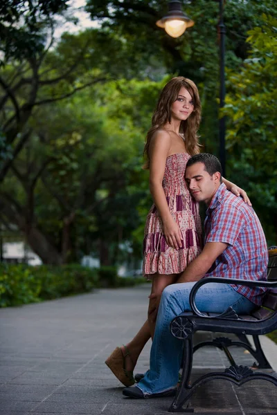 年轻夫妇谈恋爱时坐在公园的长椅上 — 图库照片