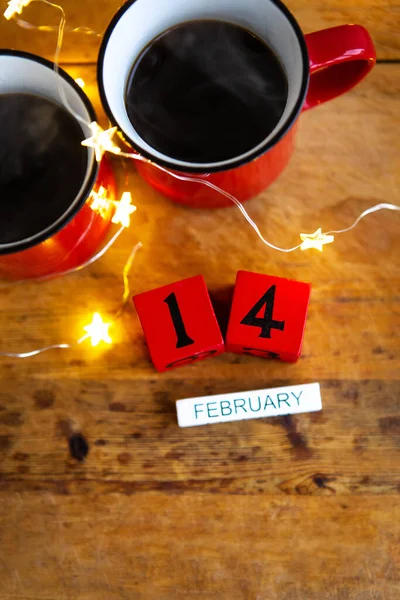 ガーランドを背景に2杯のコーヒーが赤いカップに入っている 日付と月の郵便はがき バレンタインデーの朝の朝食 上からの眺め — ストック写真
