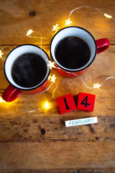 Dwie Filiżanki Kawy Czerwonych Filiżankach Tle Girlandy Pocztówka Datą Miesiącem — Zdjęcie stockowe