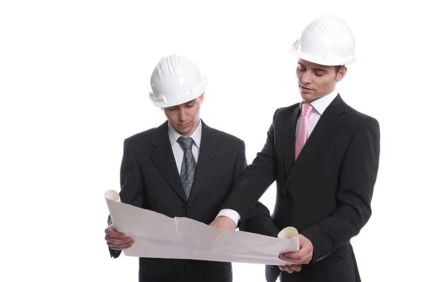 两个年轻的建筑师 头戴白色头盔 灰色背景上有一个黄色文件夹 — 图库照片