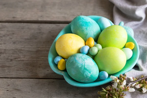 Kleurrijke Paaseieren Een Turquoise Plaat Een Armoedige Houten Achtergrond — Stockfoto