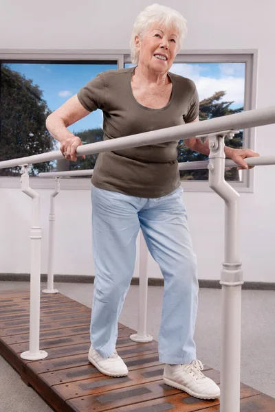 Starší Žena Cvičení Nohou Okně — Stock fotografie