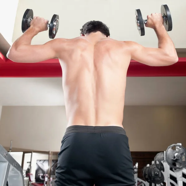 Genç Adam Spor Salonunda Dambıllarla Egzersiz Yapıyor — Stok fotoğraf