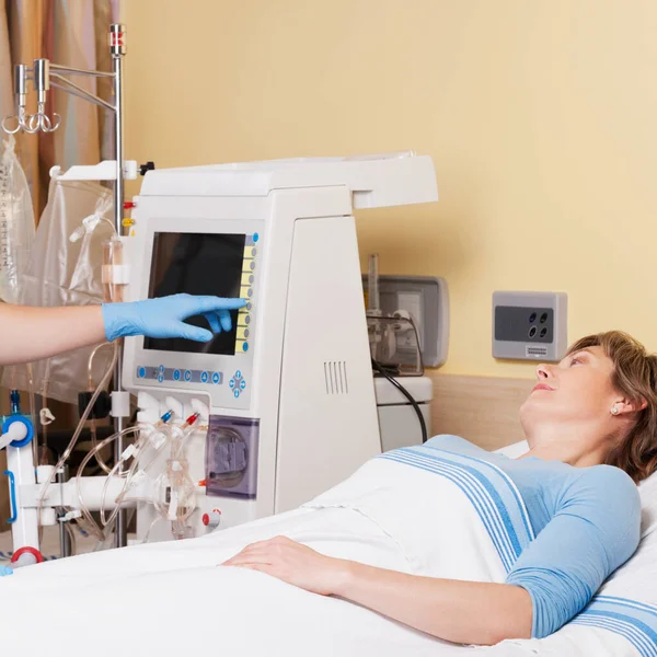 女病人躺在床上 由一名医生负责心脏监测器的工作 — 图库照片